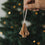 Brauner Papierbaum als Weihnachtsanhänger mit Faltoptik vor festlich geschmücktem Christbaum