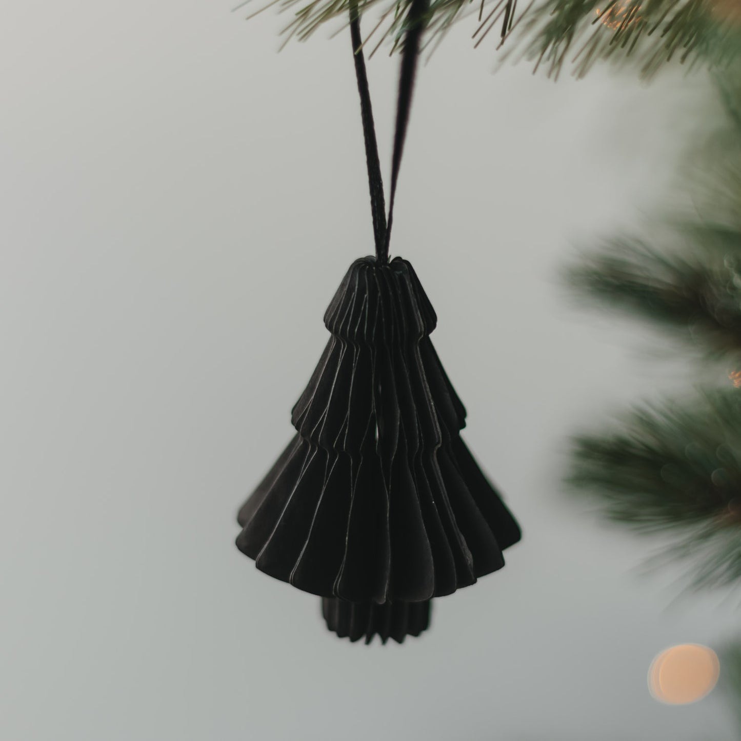 Schwarze Papiertanne mit Faltoptik als Christbaumschmuck am Weihnachtsbaum