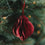 Roter Papieranhänger in Kugelform am Weihnachtsbaum mit warm leuchtender Lichterkette