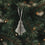Grauer Papierbaum aus Papier als stilvoller Christbaumschmuck am Tannenzweig
