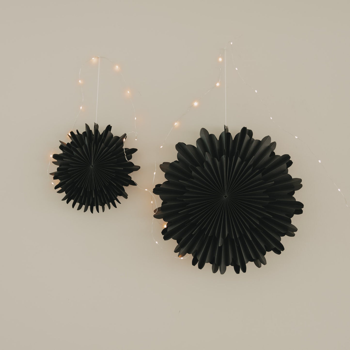 Schwarze Papierschneeflocken in 30 cm und 45 cm als moderne Wanddekoration mit Lichterkette