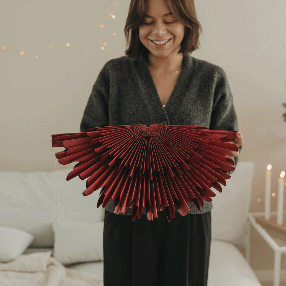 Rote Papierschneeflocke 45 cm wird aufgefaltet und als hängende Weihnachtsdekoration präsentiert