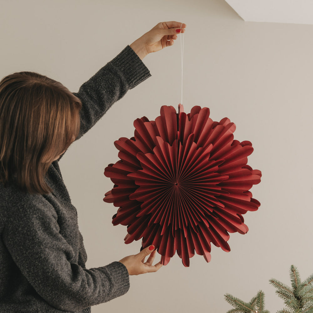 Rote Papierschneeflocke 45 cm wird als moderne Weihnachtsdekoration aufgehängt