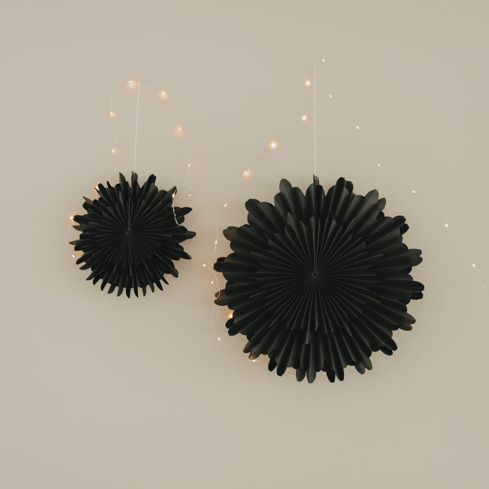 Schwarze Papierschneeflocken als elegante Weihnachtsdekoration mit filigraner Fächerstruktur