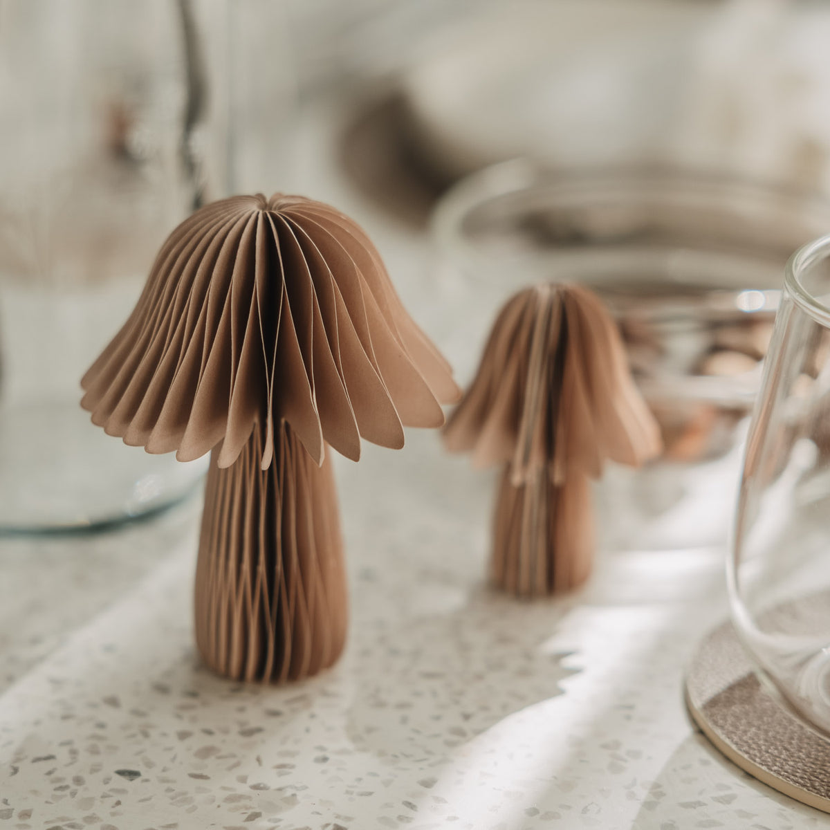 Zwei braune Papierpilze mit Wabenstruktur in verschiedenen Größen als herbstliche Tischdeko