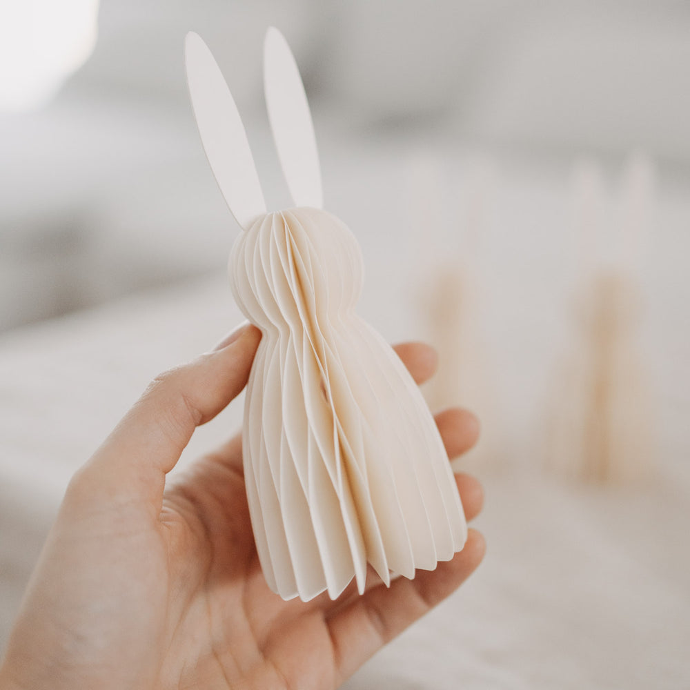 Hand hält naturfarbenen Papierhasen aus dem 3er-Set von Eulenschnitt als Osterdeko.