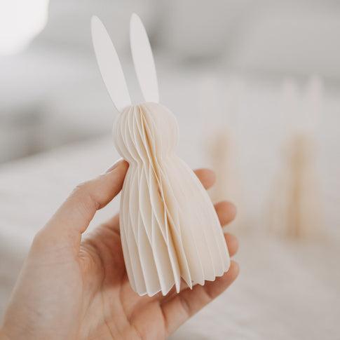 Hand hält naturfarbenen Papierhasen aus dem 3er-Set von Eulenschnitt als Osterdeko.