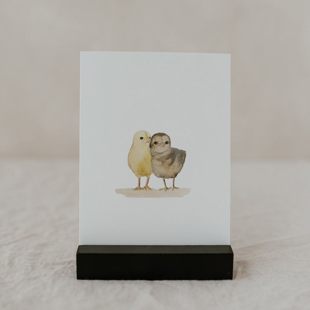 Aquarell-Osterkarte mit zwei süßen Küken im schwarzen Kartenhalter.