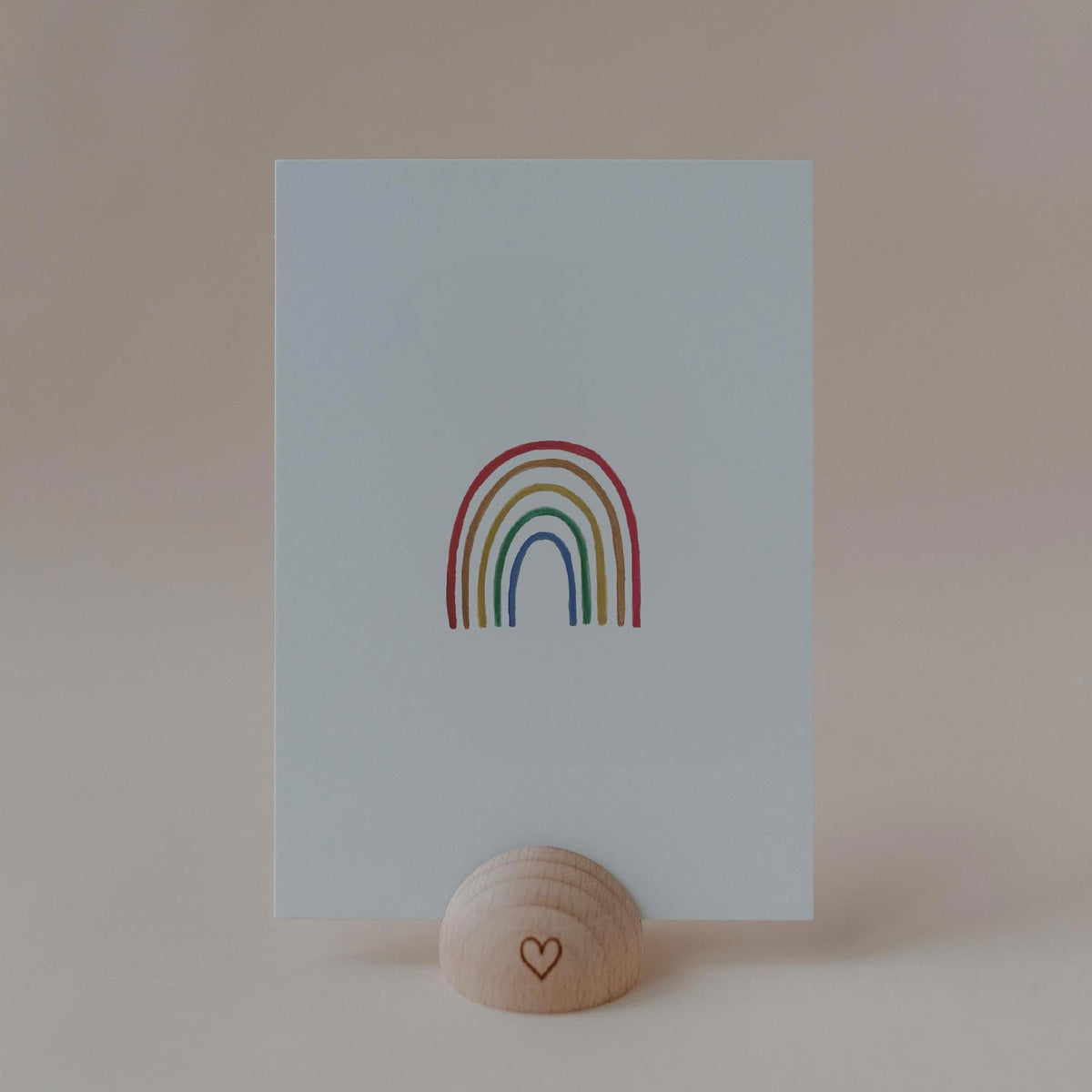 Eulenschnitt Aquarellkarte mit buntem Regenbogen auf hellblauem Hintergrund in einem Kartenhalter aus Holz.