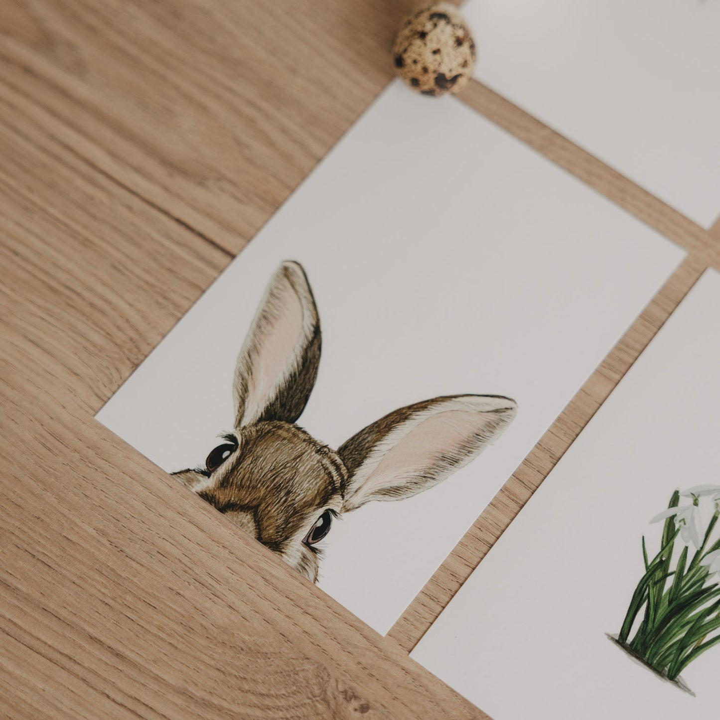 Aquarellkarte mit Hasenmotiv, Nahaufnahme der Karte zwischen Deko-Eiern.