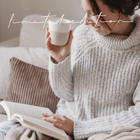 Frau liest im Wohnzimmer und hält Me Time Becher aus Keramik, Limited Edition von Eulenschnitt.