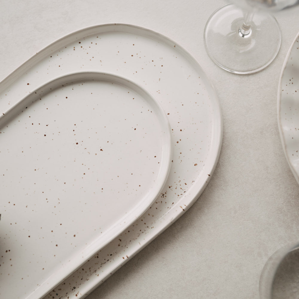 Detailaufnahme der Calma Servierplatten in groß und klein mit elegantem Rand und Sprenkel-Optik