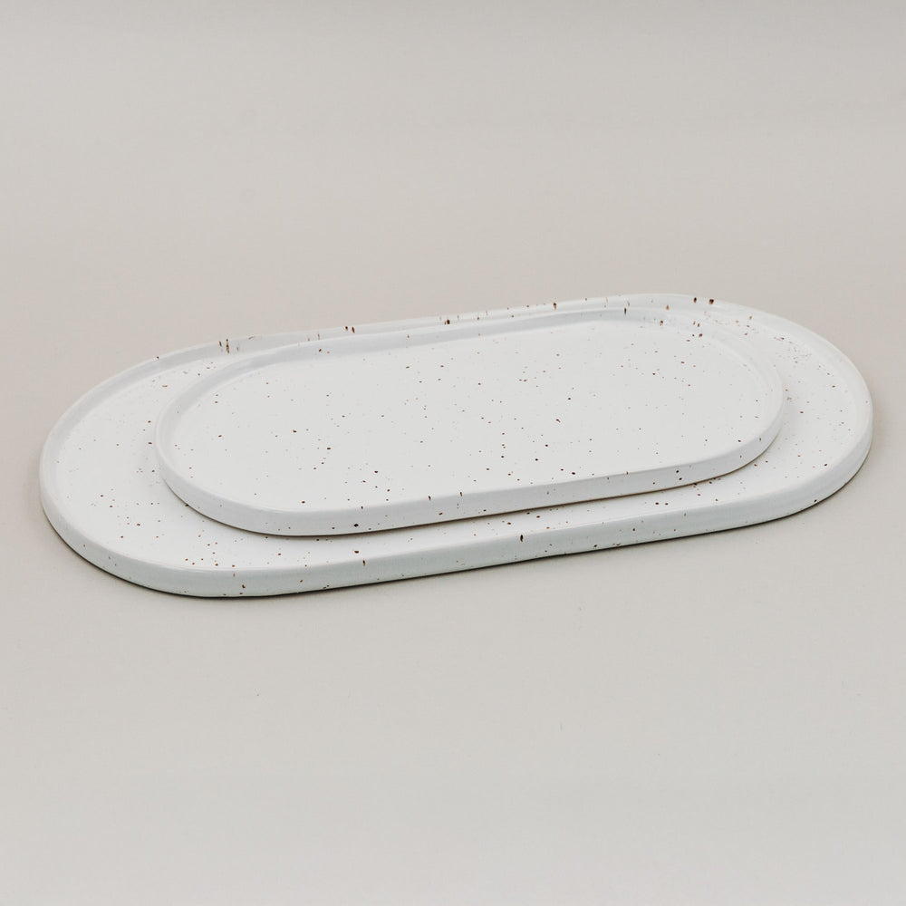 Zwei Servierplatten Calma in klein und groß aus Steingut mit feinem Sprenkelmuster im Größenvergleich