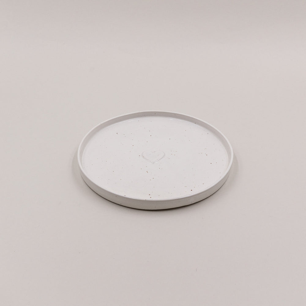 Einzelner Frühstücksteller Calma mit Herzprägung, oben fotografiert auf hellem Untergrund.