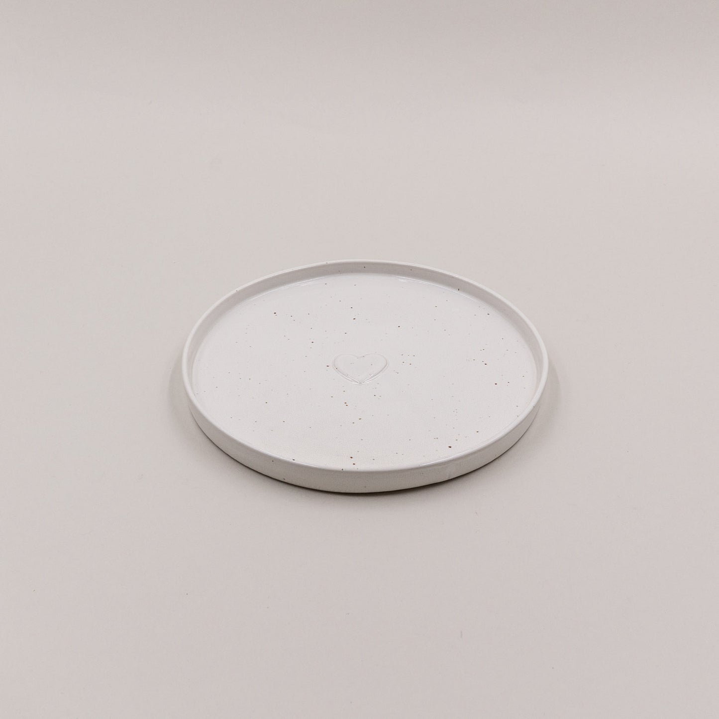 Einzelner Frühstücksteller Calma mit Herzprägung, oben fotografiert auf hellem Untergrund.