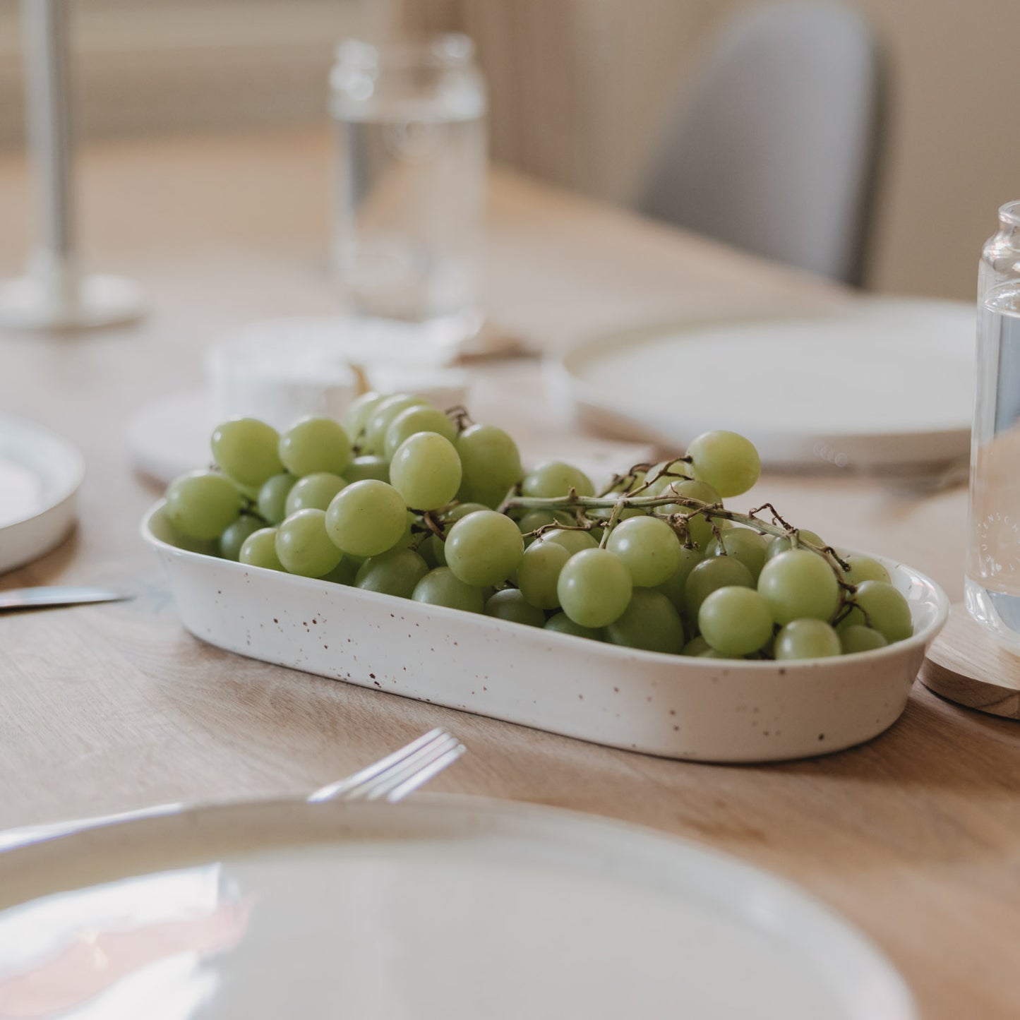 Servierschale Calma klein gefüllt mit grünen Weintrauben auf einem Holz-Tisch im Tageslicht