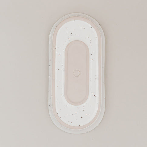 Unterseite der ovalen Servierschale Calma klein aus Steingut mit natürlichem Sprenkelmuster