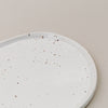 Detailansicht der Servierplatte Calma klein mit feinem braunem Sprenkelmuster im Randbereich