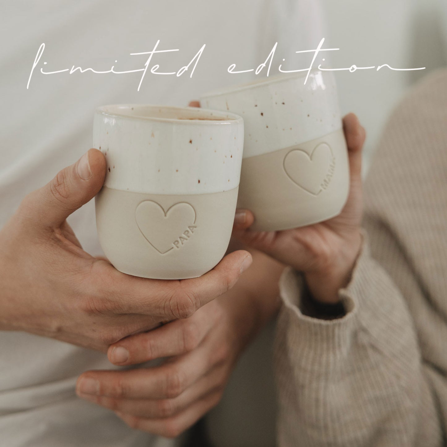 Detailaufnahme Keramikbecher Papa und Mama mit Herzprägung, in Händen gehalten