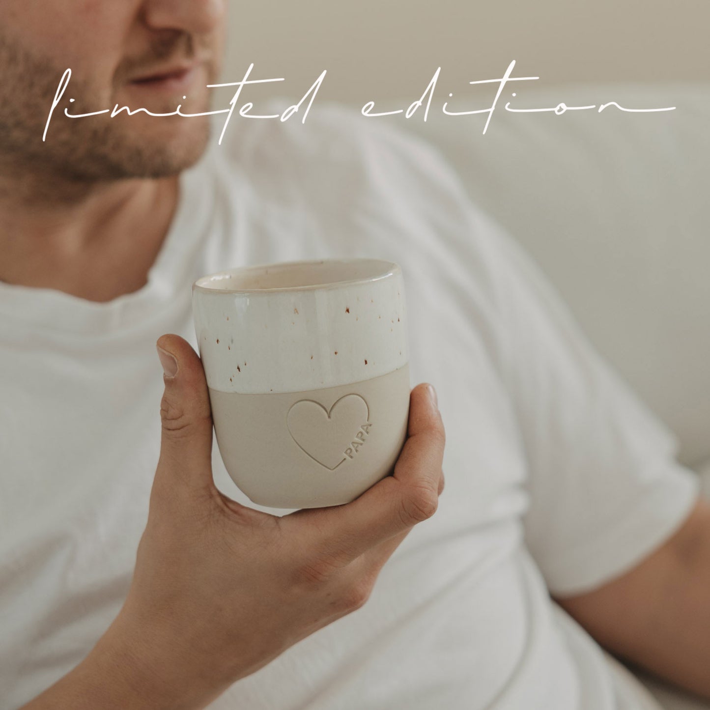 Mann hält Keramikbecher Papa mit Herzdetail, entspannt zuhause mit Kaffee, Limited Edition