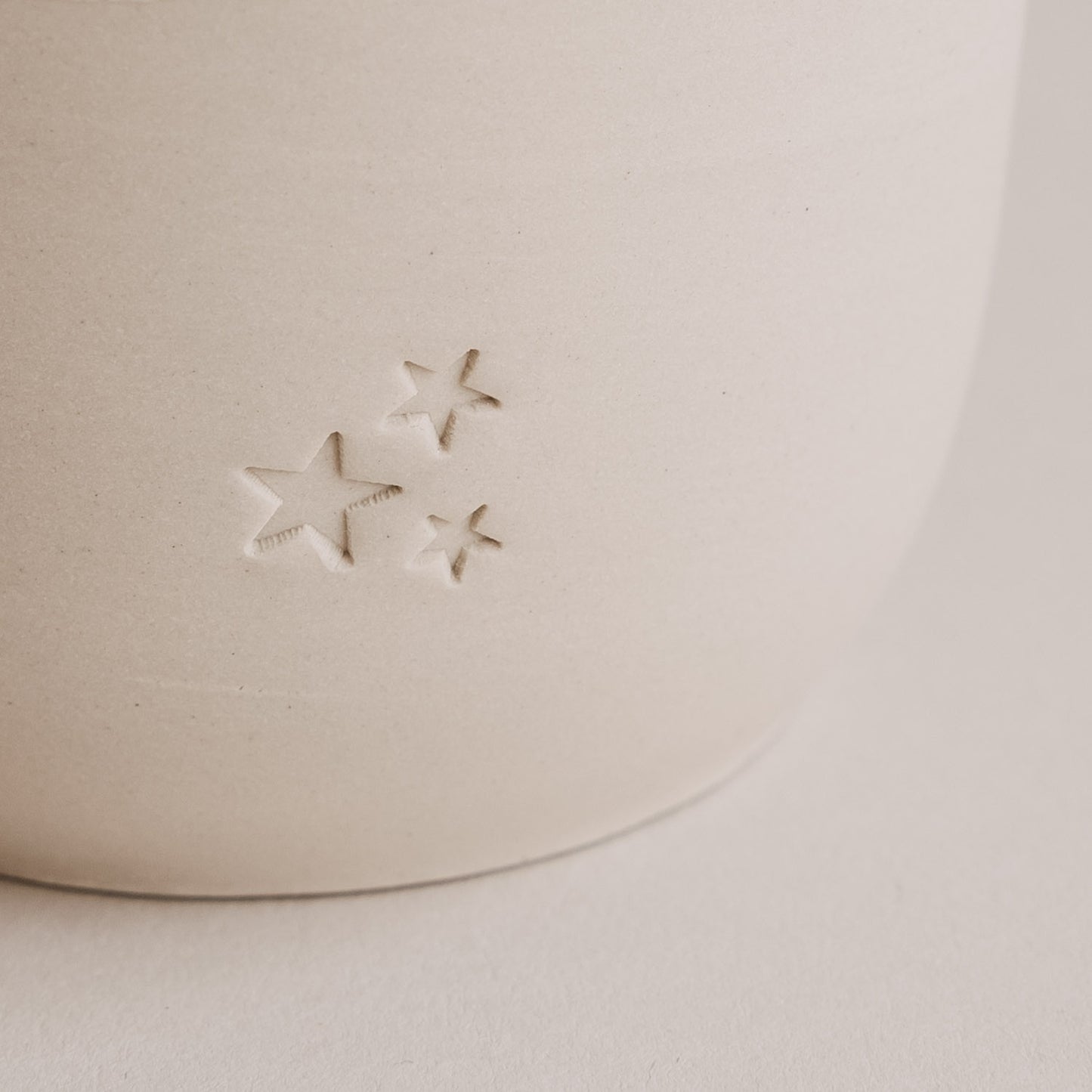 Detail Sternprägung auf Keramikbecher, dezentes Design in Beige und Weiß