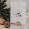 Kartenständer mit Schleifen-Gravur, dekorativ mit Weihnachtskarte und Nüssen arrangiert