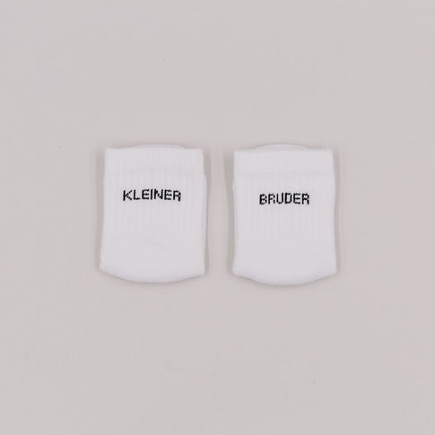 Weiße Babysocken mit Schriftzug „Kleiner Bruder“ auf neutralem Hintergrund