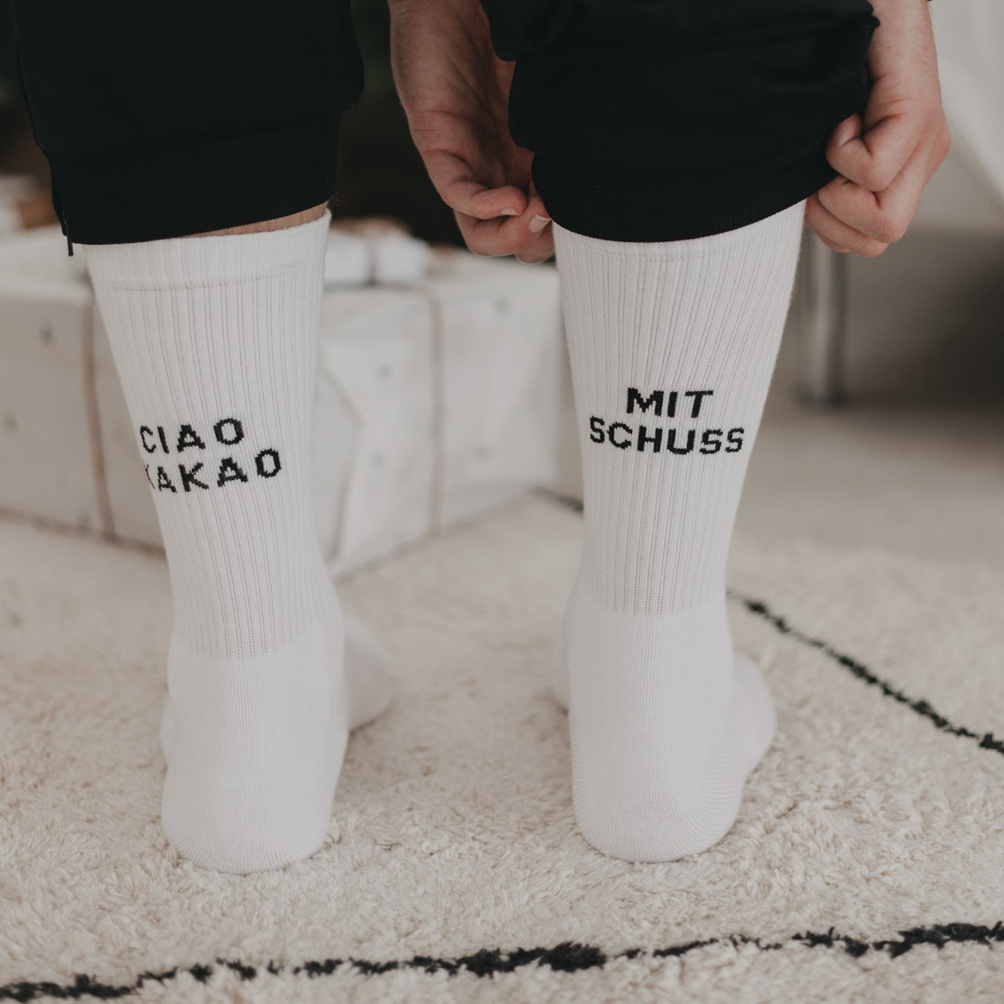 Ciao Kakao mit Schuss Socken an Füßen vor Weihnachtsgeschenken, lässig hochgezogen