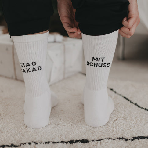 Ciao Kakao mit Schuss Socken an Füßen vor Weihnachtsgeschenken, lässig hochgezogen