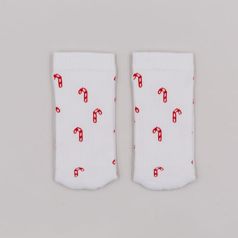 Zuckerstangen-Socken flachliegend auf weißem Hintergrund – weihnachtliches Allover-Muster in Rot.