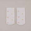 Flachliegende weiße Socken mit feinem Gänseblümchen-Muster minimalistisch dargestellt