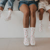 Erwachsene und Kinder tragen weiße Eulenschnitt Socken mit roten Herzen im Partnerlook.