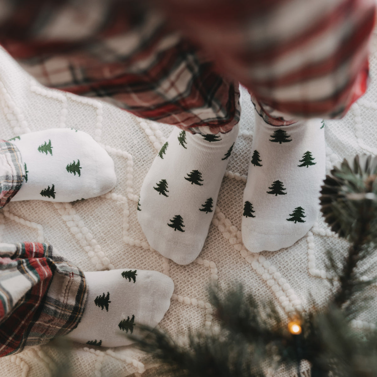Nahaufnahme weißer Kids Socken mit grünen Tannen von Eulenschnitt