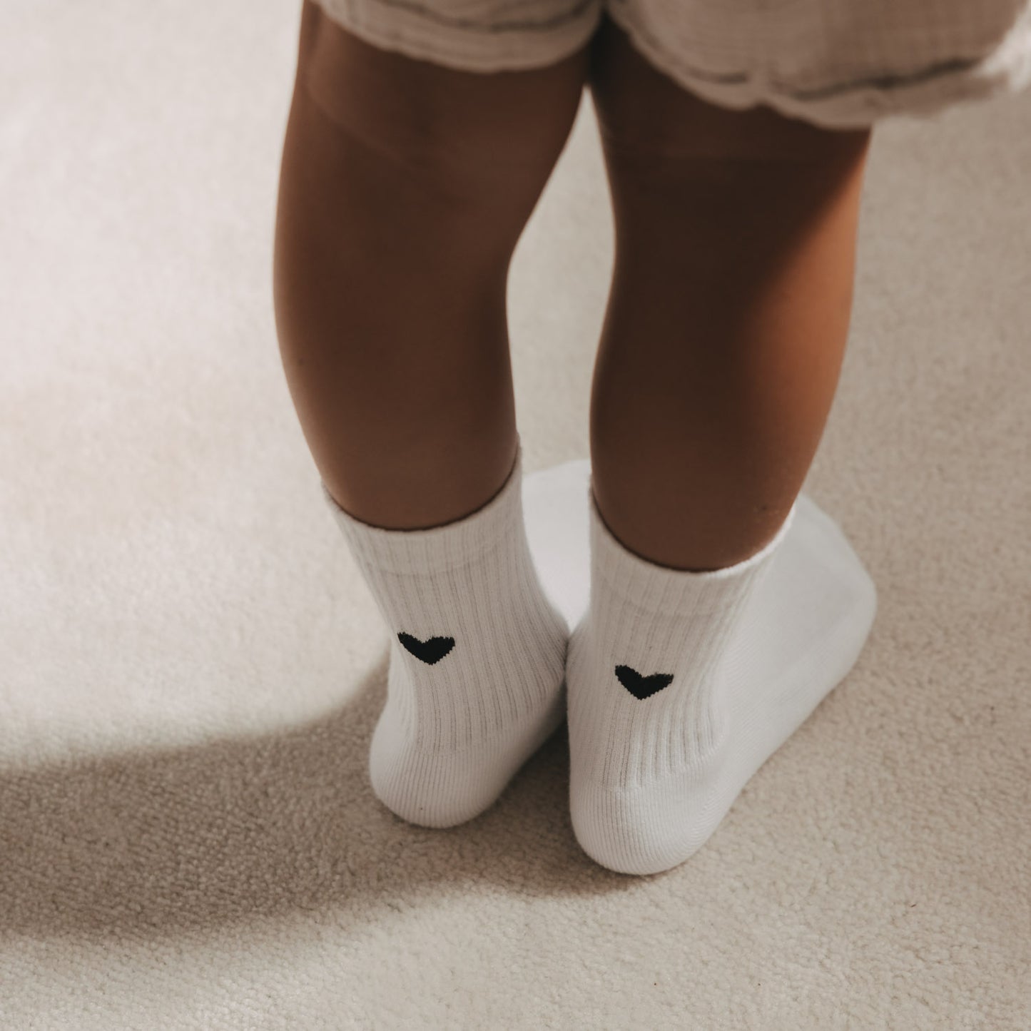 Weiße Kids Socken mit schwarzem Herzmotiv von Eulenschnitt