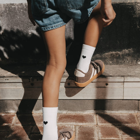 Kind trägt Kids Socken Herz schwarz von Eulenschnitt zu Jeansshorts