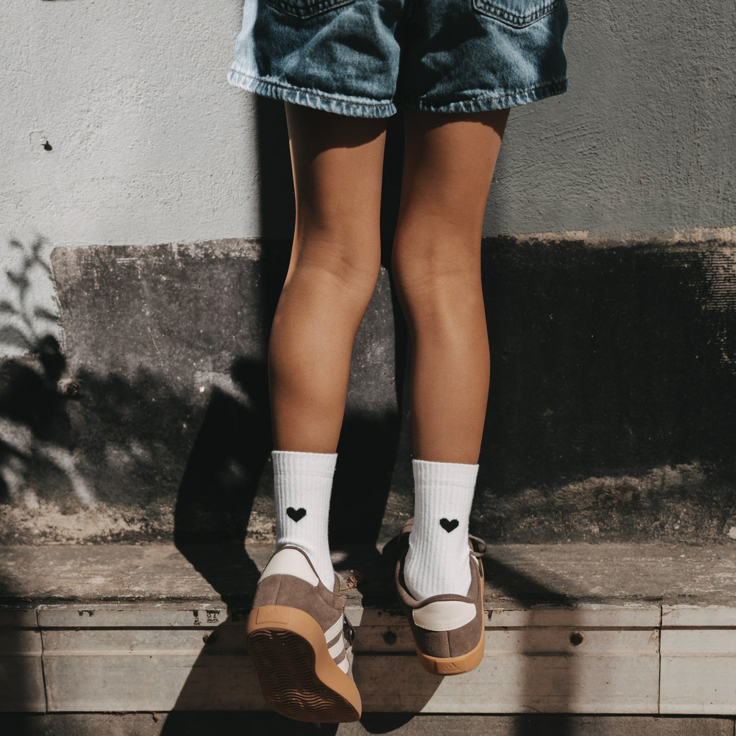Kids Socken mit schwarzem Herz zu Jeansshorts und Sneakern