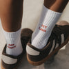 Weiße Kids Socken Der Boden ist Lava mit roter Stickerei in braunen Sneakern.