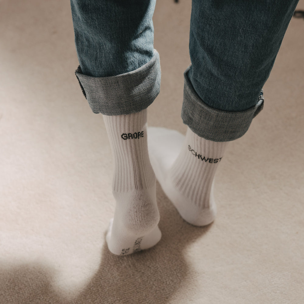 Kids Socken Große Schwester in Weiß mit schwarzem Schriftzug zu hochgekrempelter Jeans