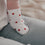 Baby trägt weiße Socken mit roten Herzen, Detailaufnahme auf Sofa, weiches Material und niedliches Design