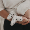 Baby liegt auf Arm mit weißen Socken und schwarzen Herzen, gemütliche Nahaufnahme