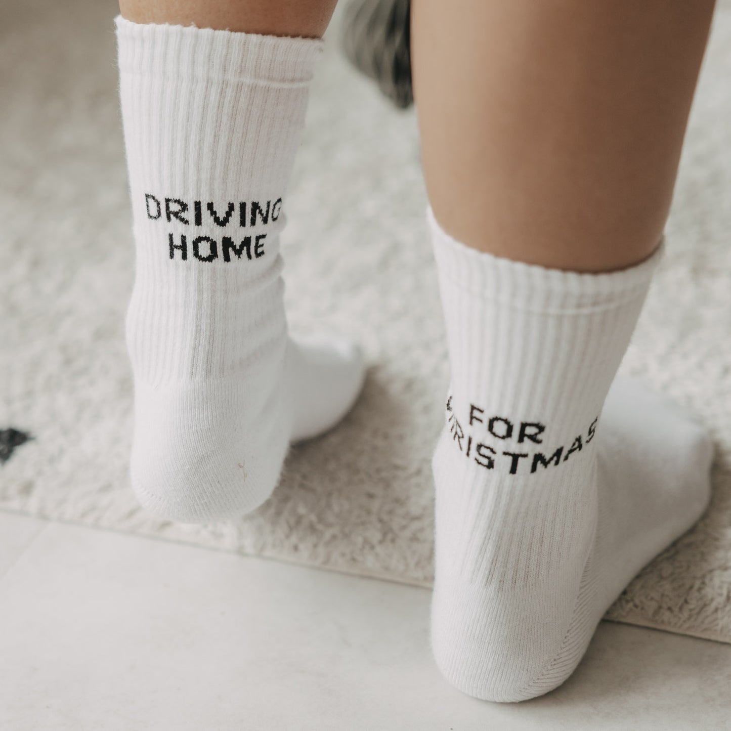 Detailansicht der weißen Socken mit Driving Home for Christmas Schriftzug