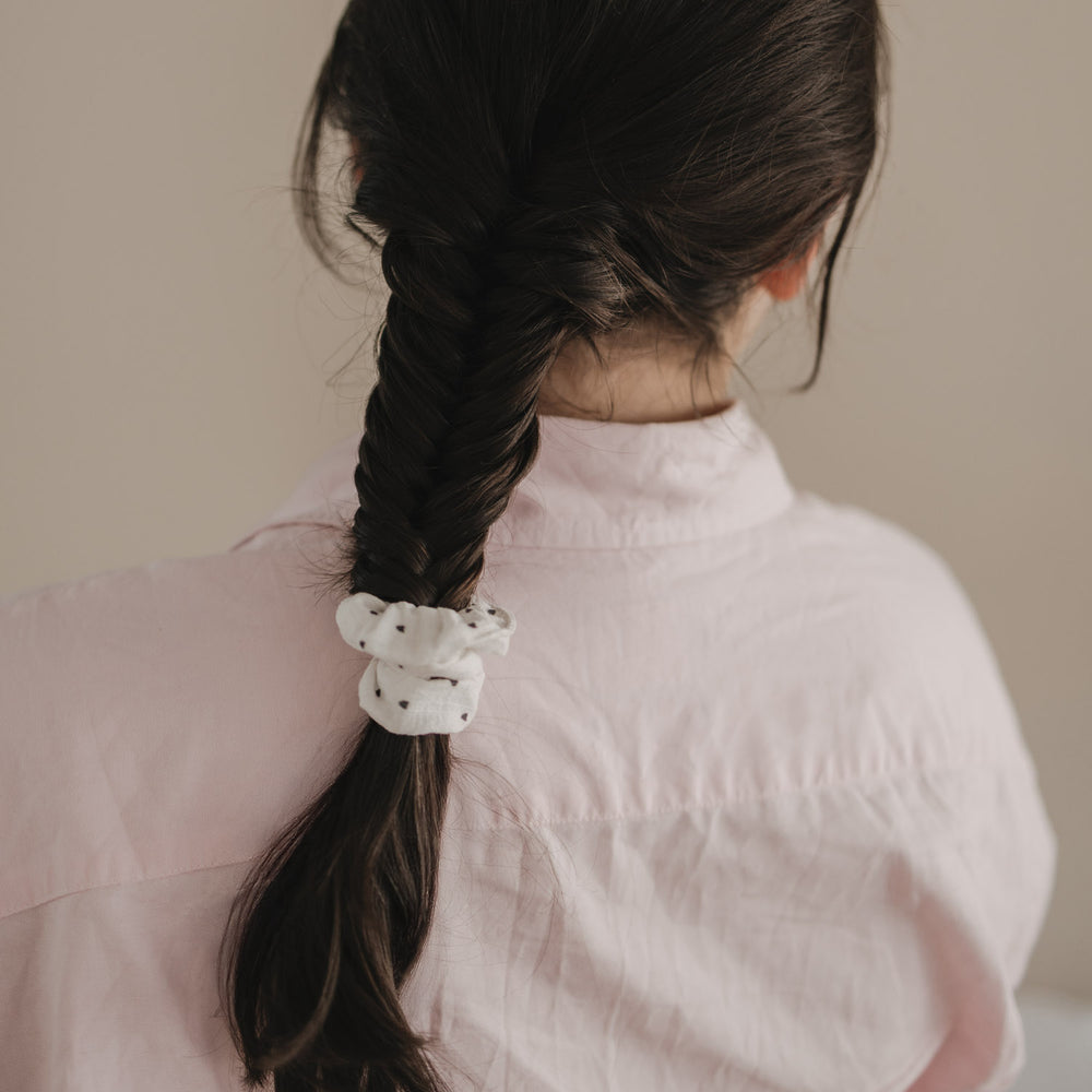 Geflochtener Zopf mit weißem Scrunchie mit schwarzen Herzen von hinten