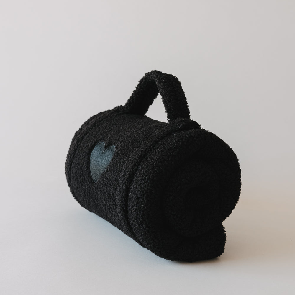 Kompakt gerollte Hundedecke schwarz mit Griff und Herz-Detail