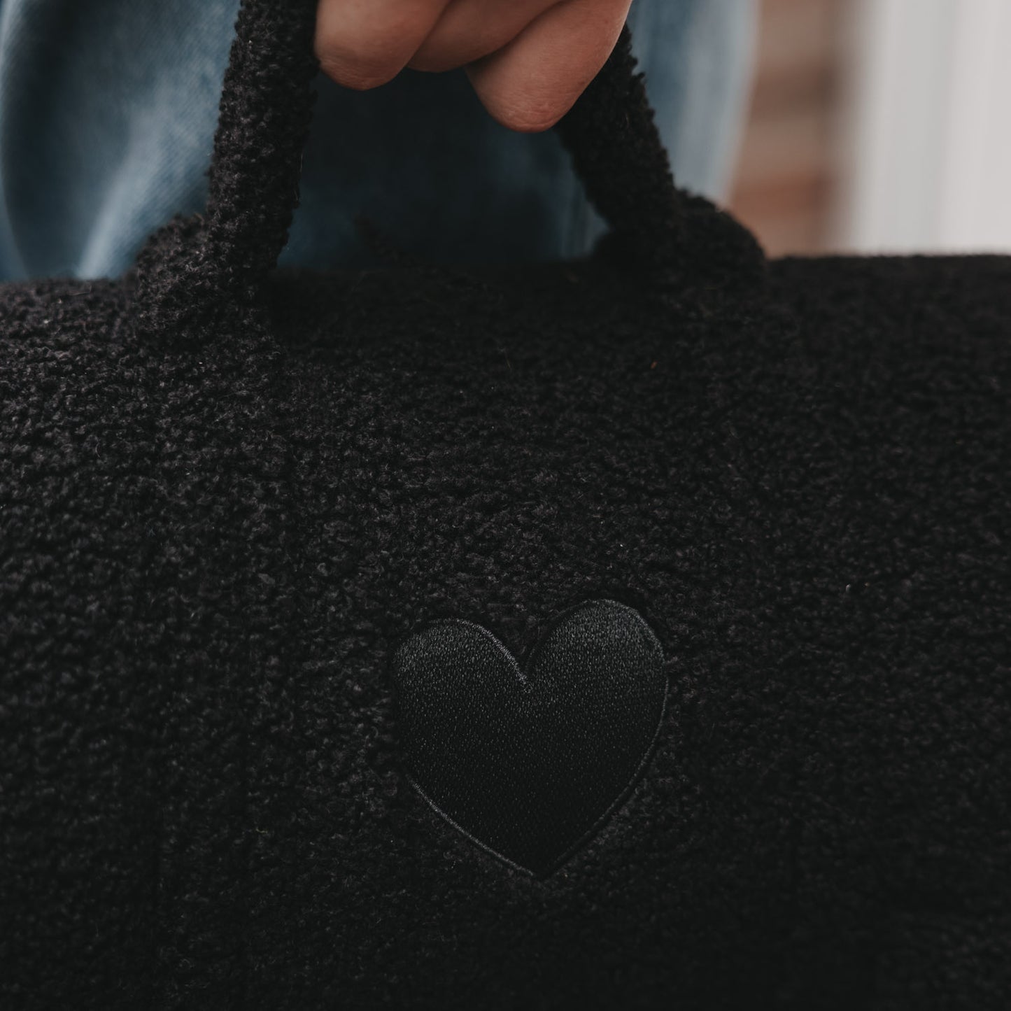 Detailaufnahme schwarze Hundedecke mit Herz-Applikation und weicher Struktur