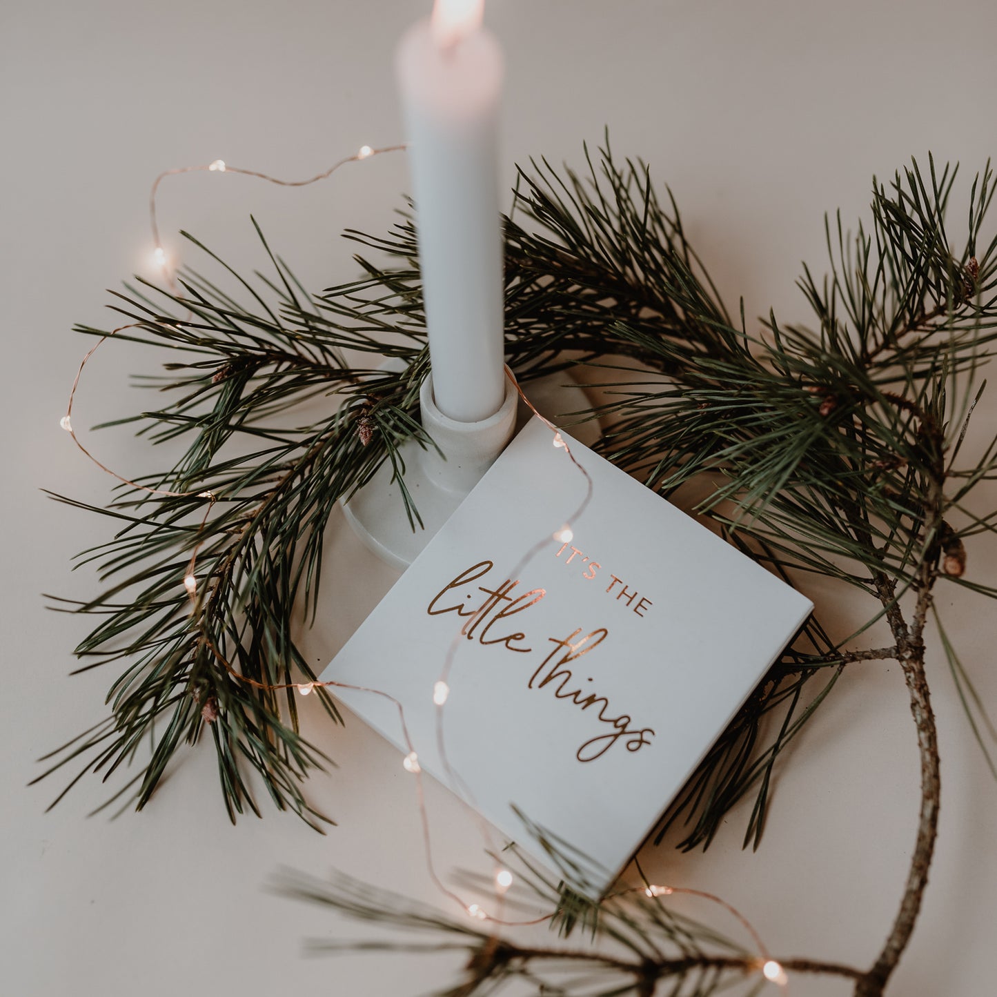 Streichhölzer „It's the Little Things“ mit goldener Schrift als stilvolle Weihnachtsdeko mit Tannenzweig und Kerze.