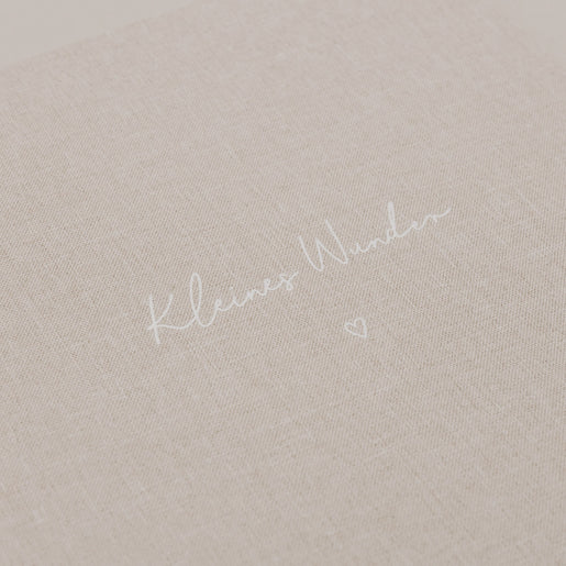 Nahaufnahme der geprägten Schrift „Kleines Wunder“ auf dem Stoffeinband.