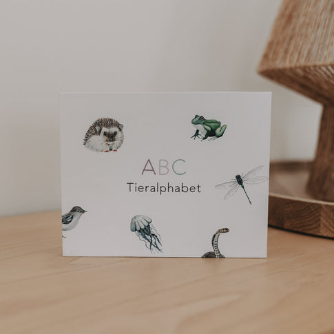 ABC Tieralphabet Box mit Tierillustrationen auf einem Holztisch.
