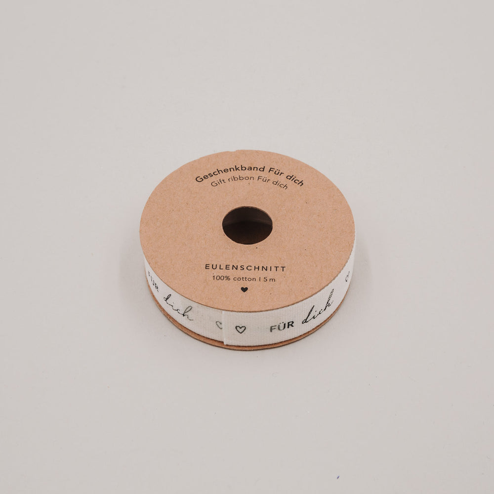 Geschenkband „Für dich“ auf Rolle aus Kraftpapier, Baumwollband mit Herzen und schwarzer Schrift.