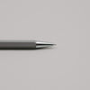 Grauer Druckbleistift mit silberner Spitze auf hellem Hintergrund, minimalistisch und elegant.
