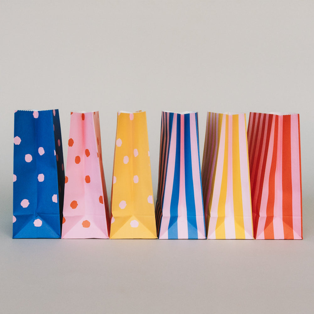 Bunte Papier-Geschenktüten aufgestellt, verschiedene Farben und Muster für kreative Geschenkideen